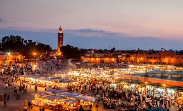 Lively city square at night in Morocco with lights and people