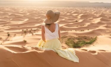 Girl walking on sand dunes in Merzouga, Morocco, Sahara Desert