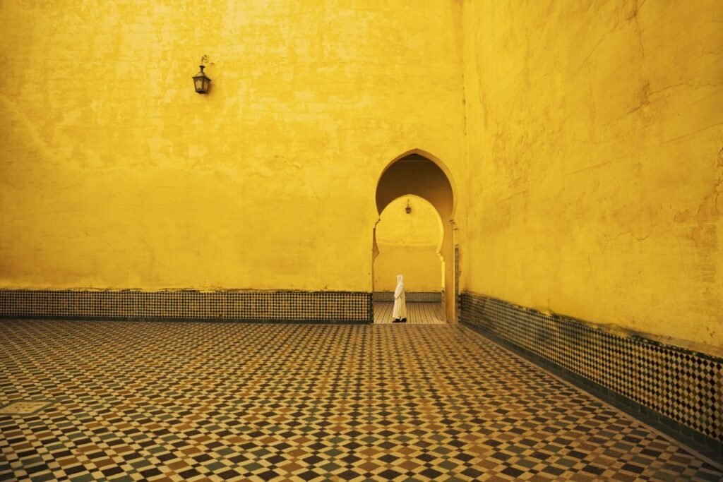 Man walking through an ornate mosaic doorway in Morocco’s historic medina