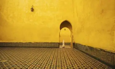 Man walking through an ornate mosaic doorway in Morocco’s historic medina
